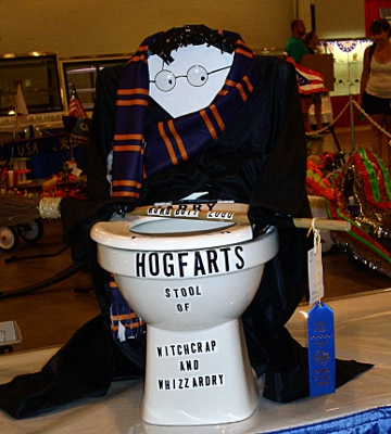 [Toilet decorated as a play on Harry Potter with blue ribbon hanging from it. Hogfarts: Stool of Witchcrap and Whizzardry.]